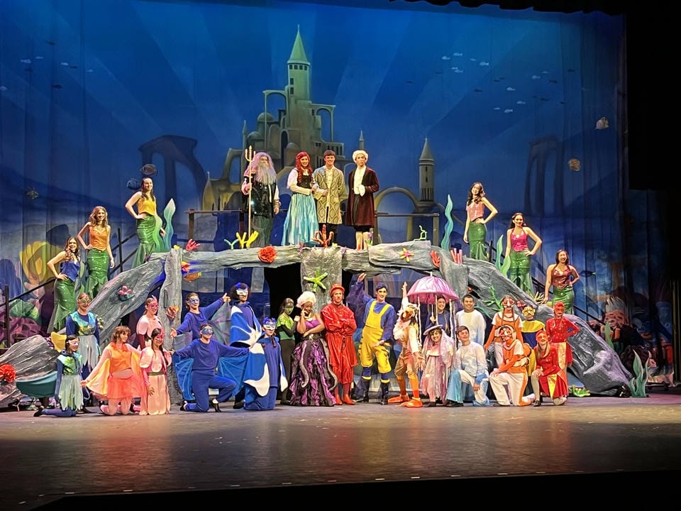 The Little Mermaid cast posing on set.