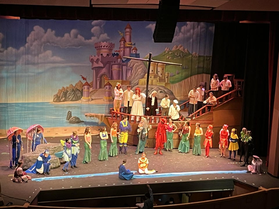 The large ship with actors on top, next to the mermaids as they learn to live in harmony at the end of the show.