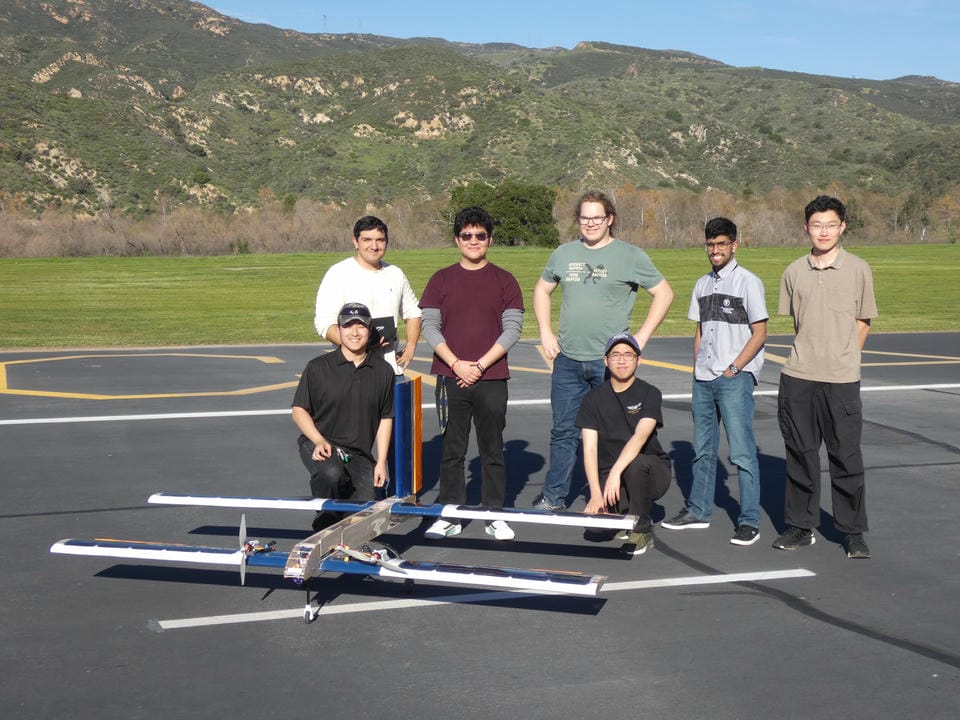 Solar airplane team beside the tandem-wing aircraft